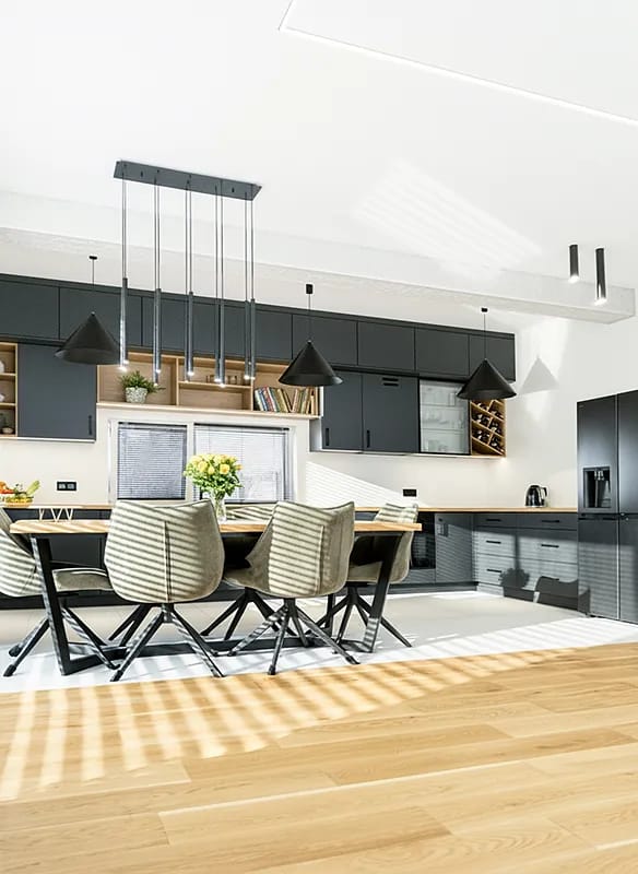 Nowoczesna kuchnia z jadalnią w stylu loftowym z grafitowymi szafkami i drewnianym stołem