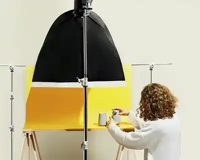 Fotograf przygotowuje sesję produktową kubka na żółtym tle z profesjonalnym oświetleniem studyjnym