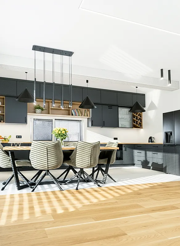 Nowoczesna kuchnia z jadalnią w stylu loftowym z grafitowymi szafkami i drewnianym stołem