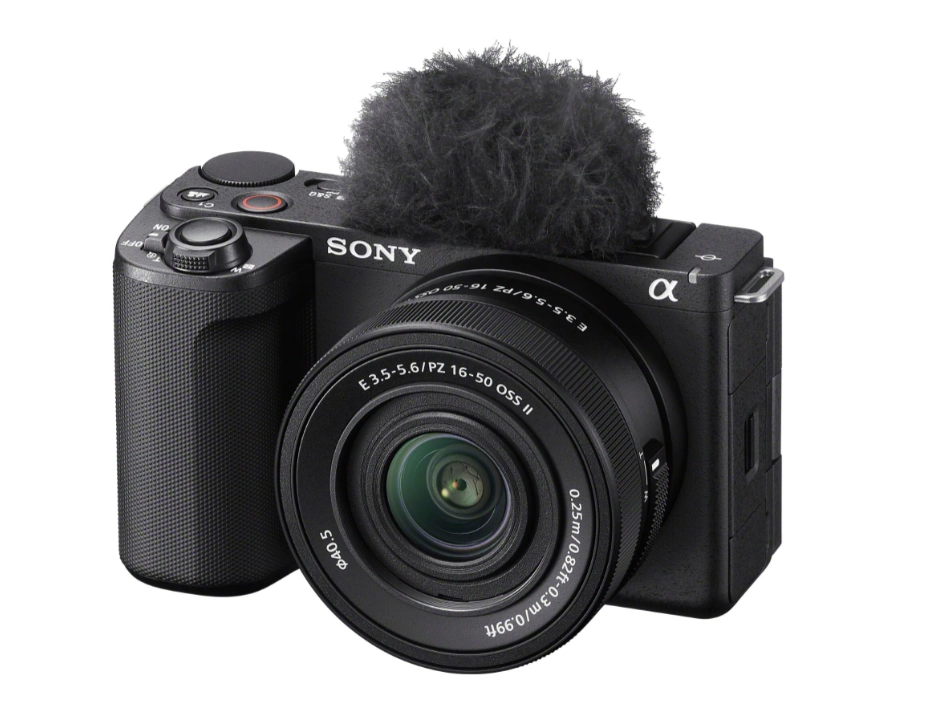 Sony ZV-E10 II z obiektywem E PZ 16-50 mm OSS II i futrzaną osłoną na mikrofonie, widok z przodu pod kątem